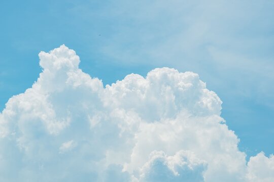 Fluffy white clouds in blue sky. Cumulus cloud formation.