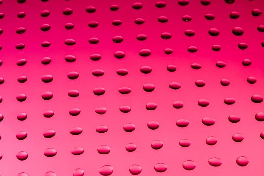 Pink tactile signage surface. Braille dots pattern