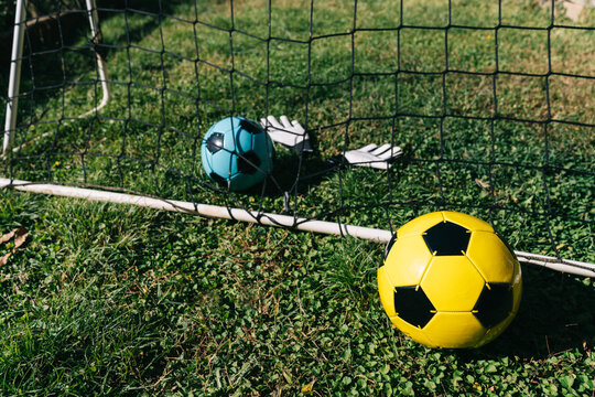 Soccer equipment arranged in goal net on grass