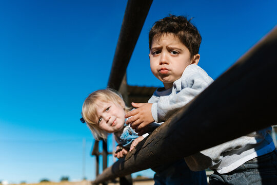 Children looking over fence with curious expression