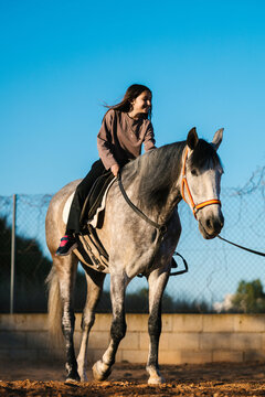 Young girl enjoying horse riding during leisure time