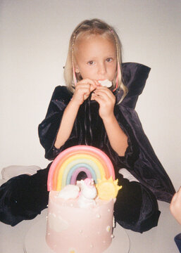 Little Girl Celebrating Birthday With Rainbow Cake