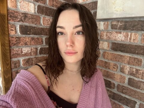 beautiful young woman with natural look posing against a brick wall