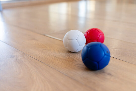 Playing bocce balls indoors with red white blue