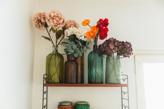 Vintage Glass Vases with Flowers on Shelf