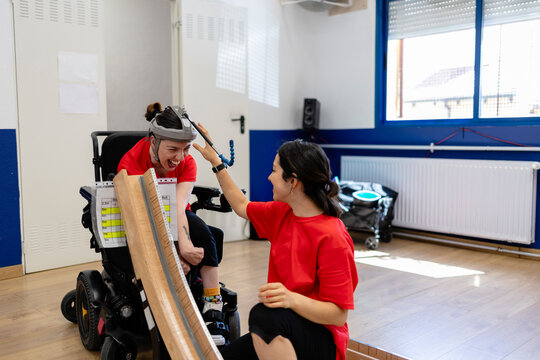 Person with disability high fiving therapist during activity