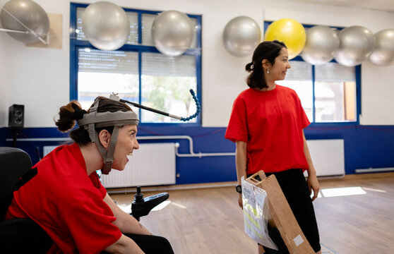 Woman with head pointer participating in rehabilitation activity