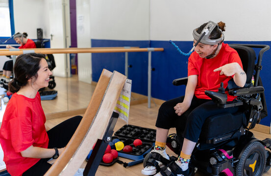 Woman with disability playing boccia with caregiver
