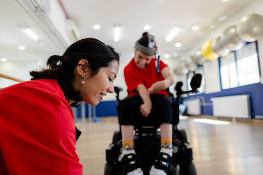 Therapist assisting young person with mobility disability