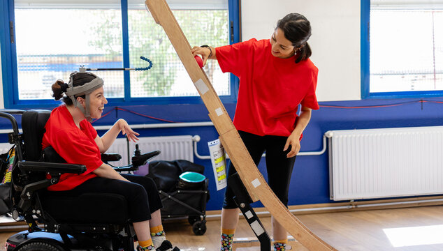 Woman with disability interacting therapist using assistive device