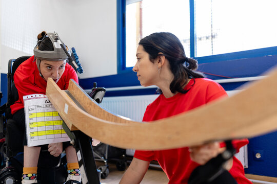 Woman with disability learning assistive technology with instructor