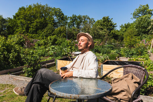 Relaxed Man Drinking Coffee in Urban Garden