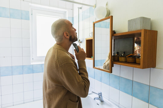 Man Trimming Beard with Electric Clipper