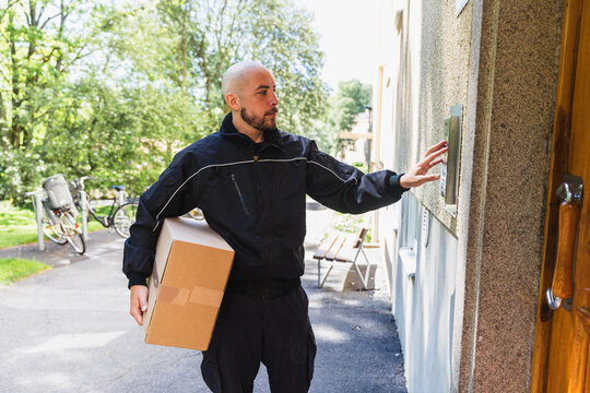Delivery Man Using Apartment Intercom System