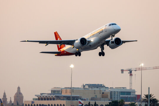 Luqa, Malta - July 16, 2026: Helvetic Airways Embraer 190 E2 STD (ERJ-190-300STD) (REG: HB-AZC) taking off runway 13 in the sunset.