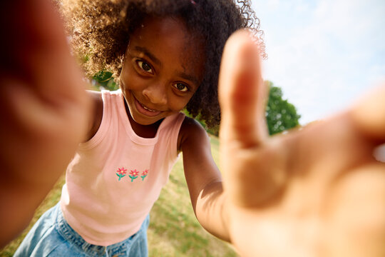 Happy little girl facing the camera in a park