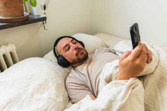 Close Up of Man Checking Phone in Bed