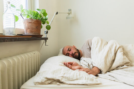 Peaceful Man Sleeping in Cozy Bed