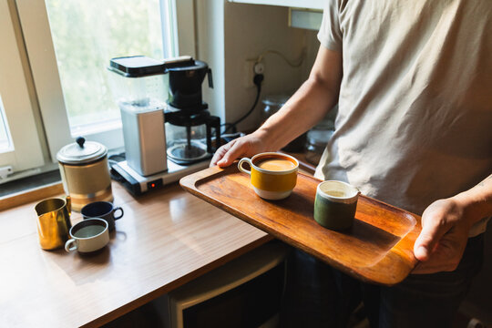 Man Carrying Coffee Tray in Kitchen