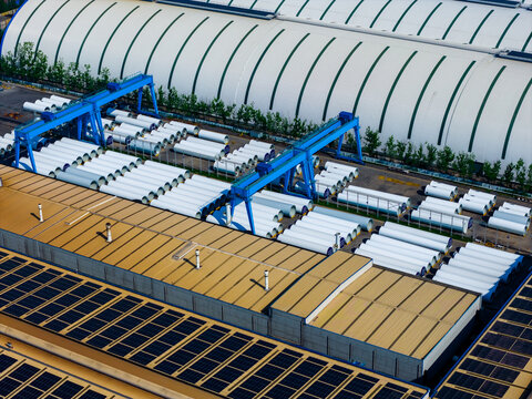 wind turbine blade components in factory yard with gantry crane