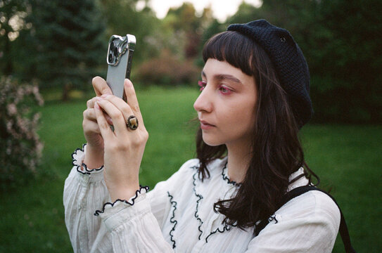 Woman taking a picture with smartphone in a park