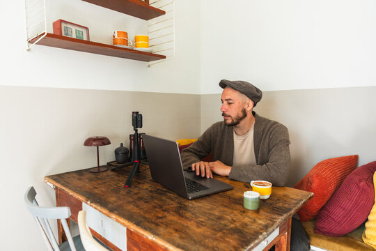 Man Working on Laptop at Wooden Table