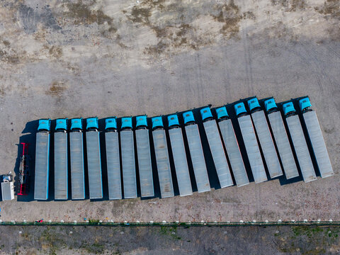 blue trucks with trailers parked in a row