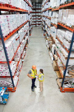Logistics managers discussing inventory in warehouse
