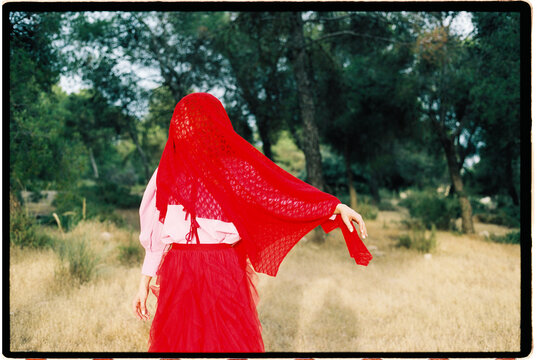 Woman wearing red veil in forest