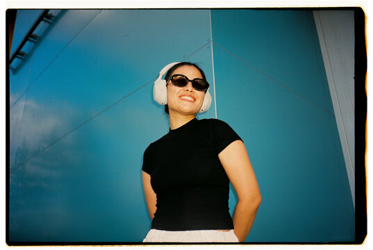 Smiling Woman Wearing Wireless Headphones and Sunglasses
