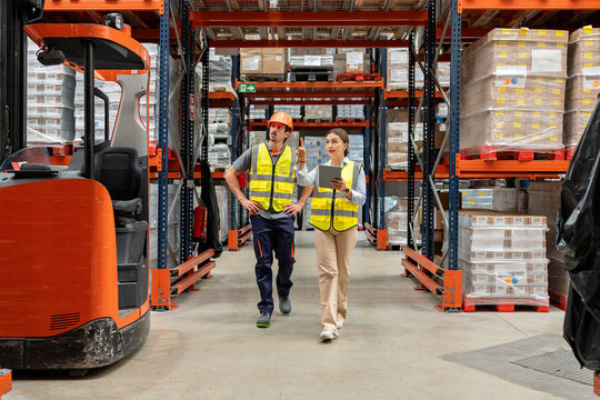 Warehouse workers discussing logistics and inventory management