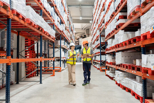 Warehouse workers discussing inventory management in logistics center