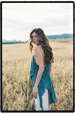 Woman with flowing hair in golden wheat field
