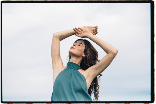 Woman with eyes closed and raised arms