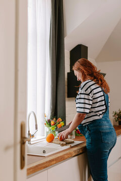 Pregnant woman preparing orange juice in  the kitchen 