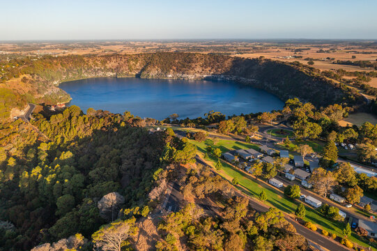 Golden light over a caravan park on the side of a deep crater lake