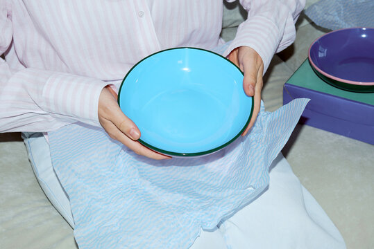 Person unpacking blue bowl 