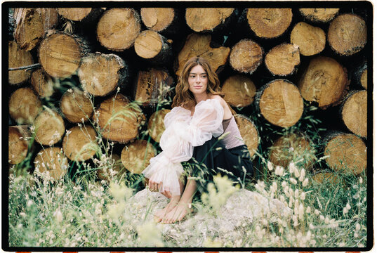 Woman with puff sleeve dress among logs