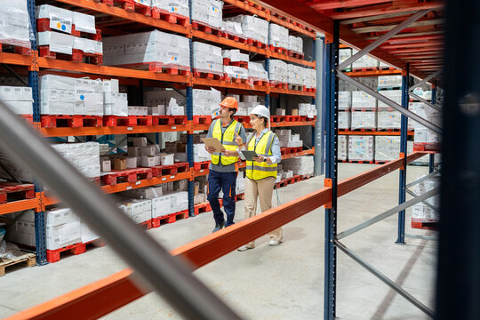 Warehouse workers discussing logistics and inventory management