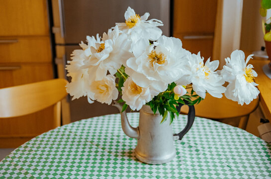 Flowers in a kettle on a table 