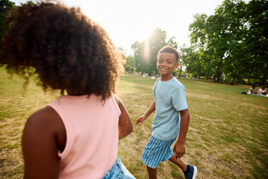 Happy boy facing the camera while walking with his sister