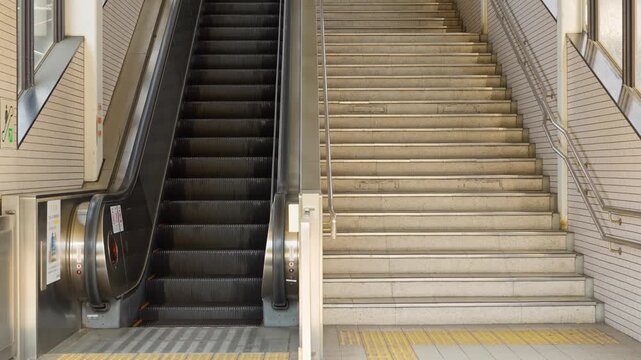 日本の駅に設置されたエスカレーターと階段。ループ可。非常停止ボタンと安全警告ステッカー。アイレベル