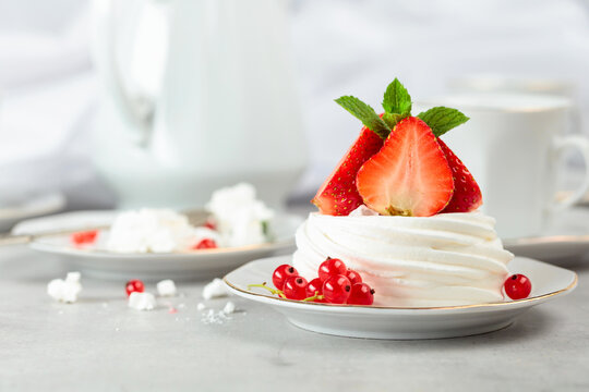 Pavlova dessert with strawberries, red currant, and mint.
