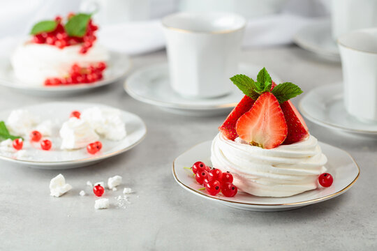 Pavlova dessert with strawberries, red currant, and mint.