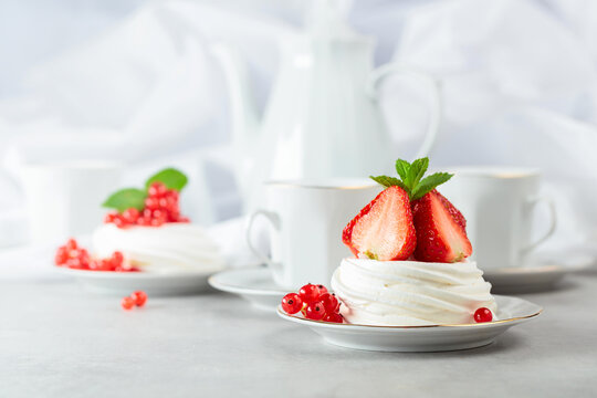 Pavlova dessert with strawberries, red currant, and mint.
