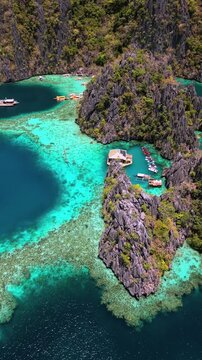 Aerial drone view of coral reef formation in Twin Lagoon, Coron, Palawan, Philippines. Turquoise water, limestone cliffs, and tropical island landscape.