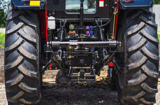 Rear three point hitch of modern agricultural tractor, hydraulic lifting system for farm implements, precision farming equipment, closeup of heavy machinery engineering.