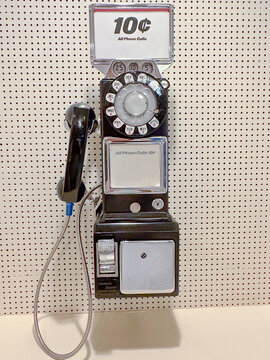 Vintage black pay telephone on pegboard wall with blank area for type