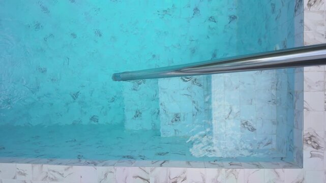 Aerial View of a Luxury Swimming Pool with Turquoise Water and Marble Deck