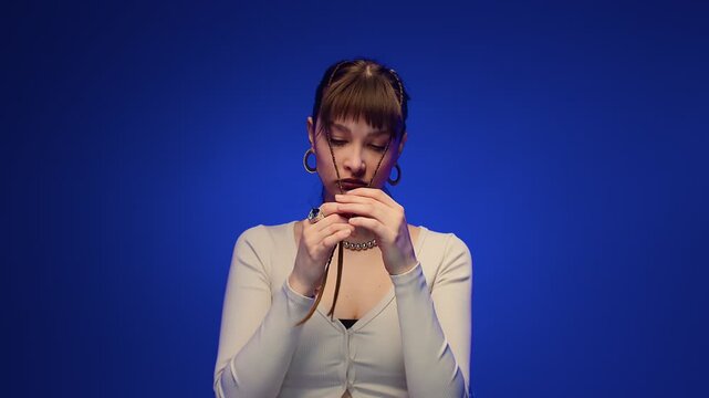 Braided Young Woman Making Playful Kissy Face in Blue Studio Portrait with Cool Fashion Styling Look